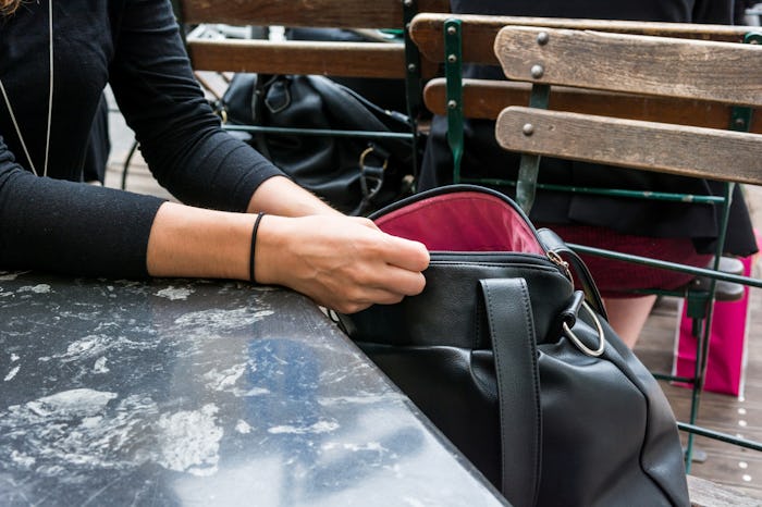 A woman with mommy brain looking through her purse while at a cafe