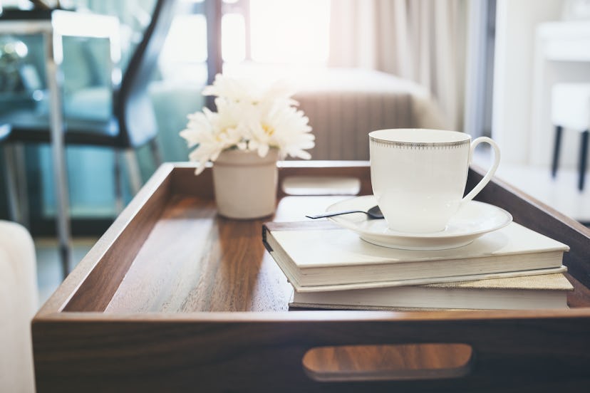 Wooden Coffee table with coffee, books and flower on it 