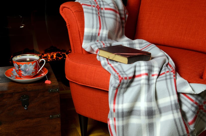 Cozy blanket on the sofa, and next to it, tea on the table 