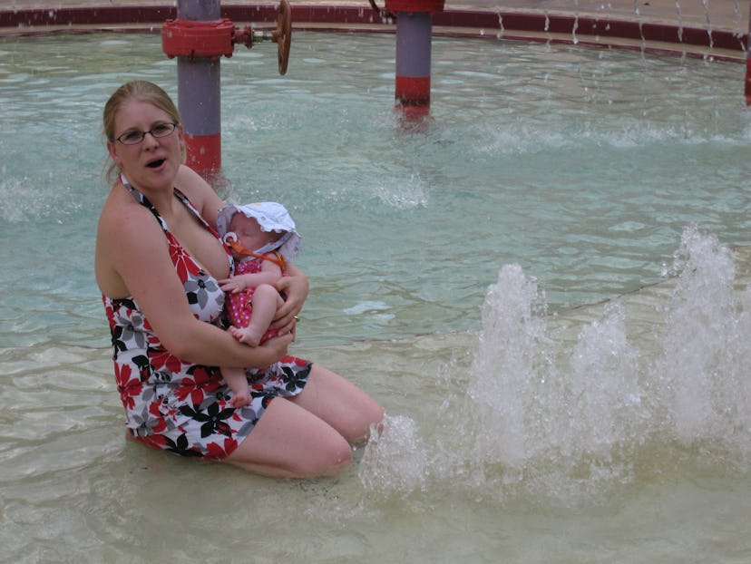 A woman breastfeeding her baby while sitting in a pool