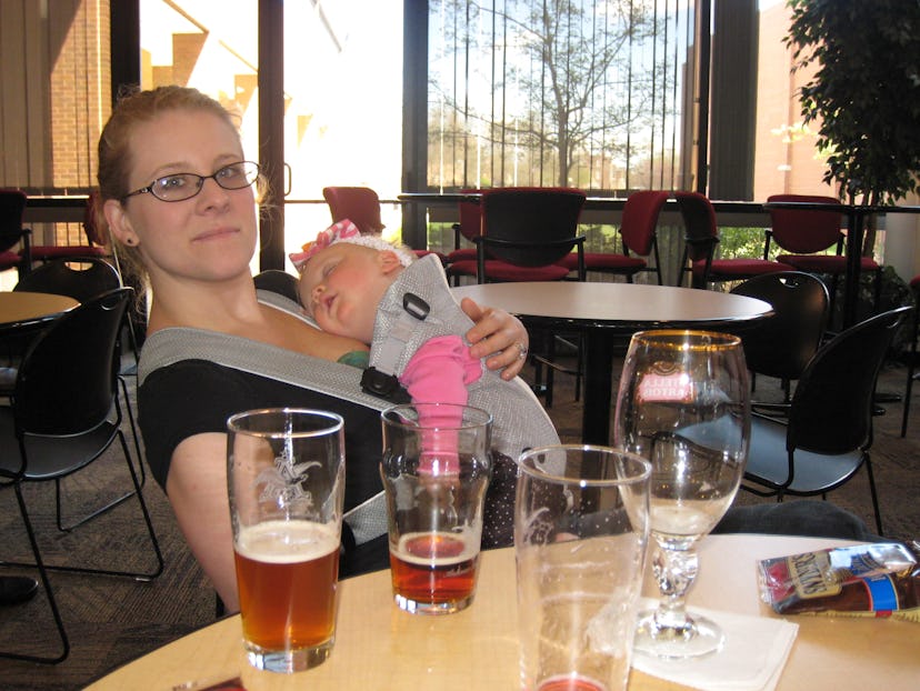 A mother holding and hugging her baby while sitting in a restaurant 