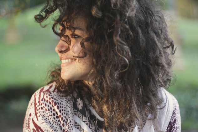 A girl with brown curly hair photographed from her side profile