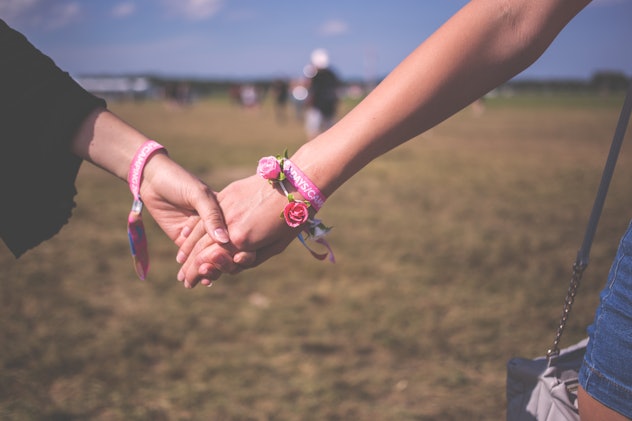 Two girls with flower bracelets holding hands