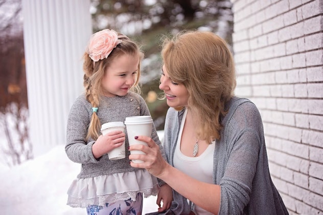 A mother and daughter holding coffee mugs