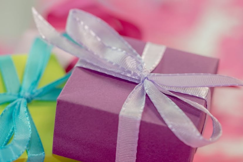 Image of a present wrapped in a purple box with a gray bow