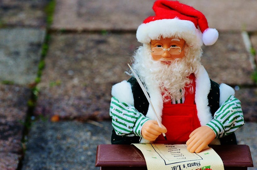 A toy of a tiny Santa toy writing a letter
