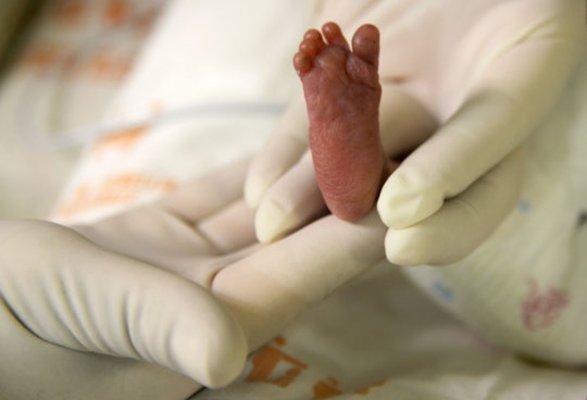 A close-up of a doctor checking the foot of a prematurely born baby