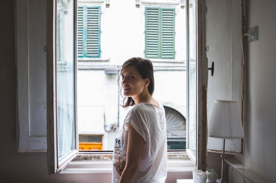 A woman in a white shirt near an open window