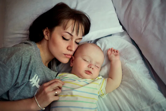 A bed-sharing mom sleeping next to her baby