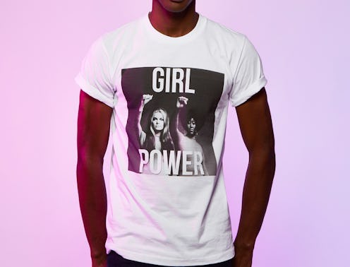 A man wearing a white shirt that says girl power in front of a pink background