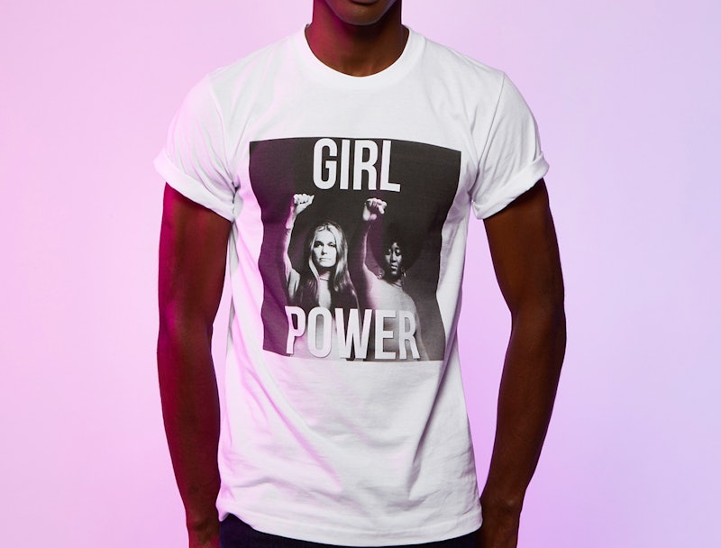 A man wearing a white shirt that says girl power in front of a pink background