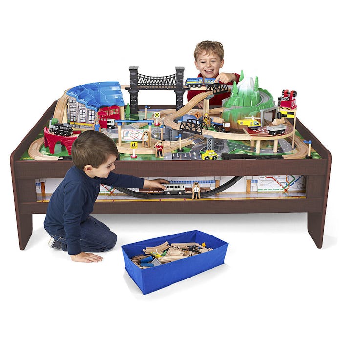 Two boys playing on a miniature train table imaginarium metro line train