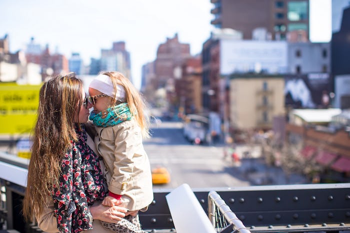 A mother struggling with social anxiety leaning towards her daughter while holding her.
