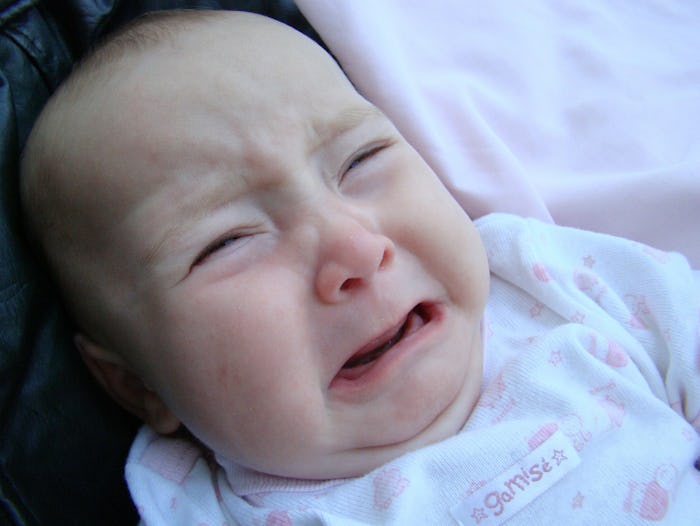 A close-up of a crying baby who has an ear infection