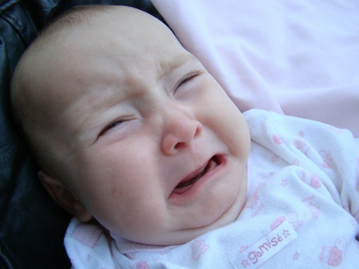 A close-up of a crying baby who has an ear infection