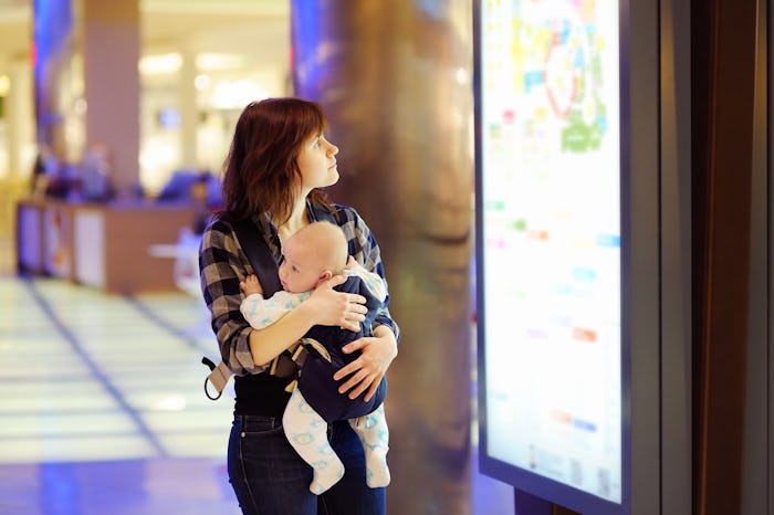A mother walking and carrying her baby