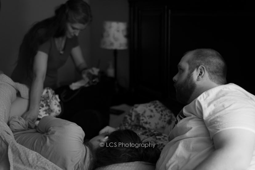 A woman preparing for a home birth surrounded by her family