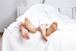 Couples feet sticking out from beneath the covers after struggling to have an orgasm
