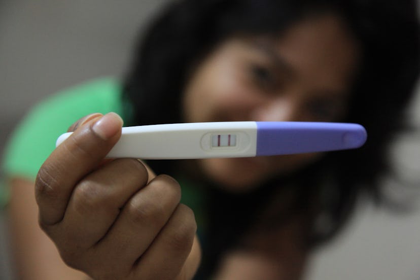 A woman showing a positive pregnancy test