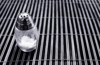 Salt shaker on a table mat, black and white photo