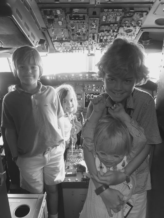 Four kids posing for a photo in a plane cockpit 