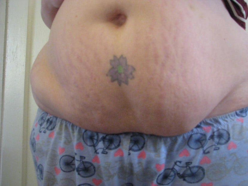 Fourth week image of Katherine DM Clover with stretch marks and a tattoo of a flower