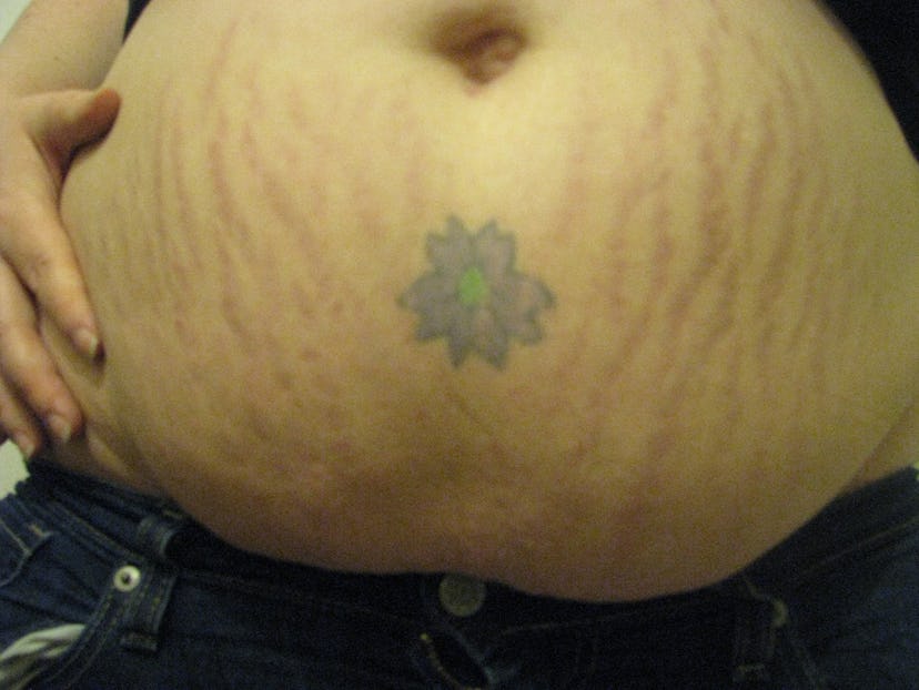 First week image of Katherine DM Clover with stretch marks and a tattoo of a flower