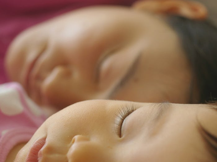 A close-up of a parent's and toddler's face while they're asleep
