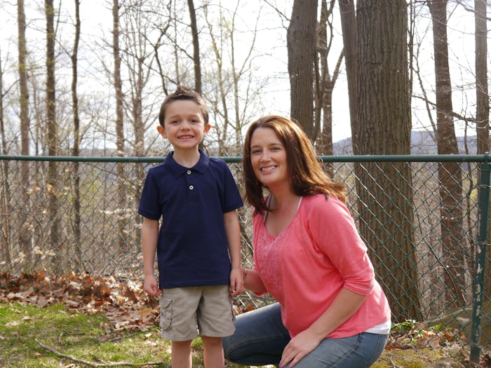 Sarah Clouser posing and squatting next to her son, whom she held back from kindergarten