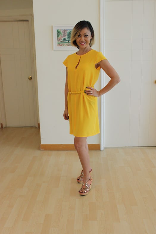 A woman dressed by her 3-year-old in a yellow dress
