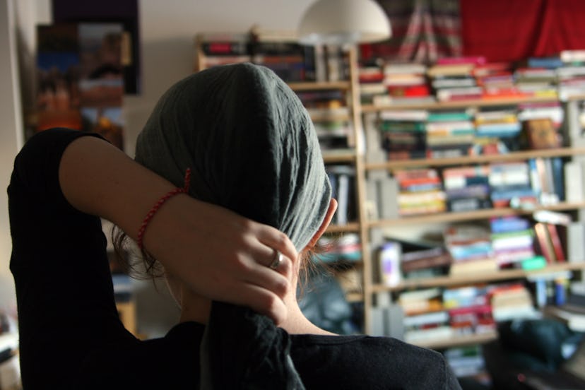 a woman ties her headscarf