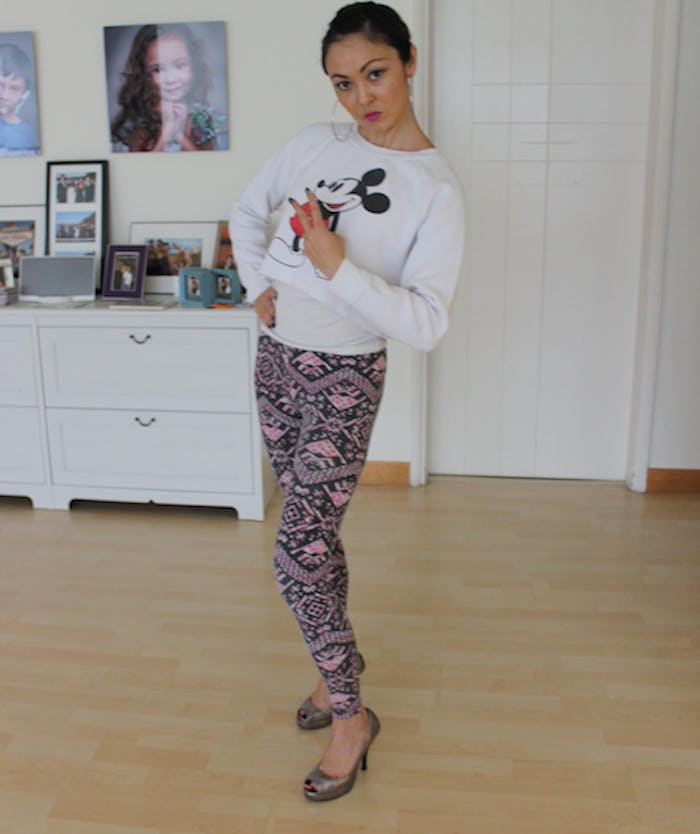 A woman dressed by her 3-year-old in a white Mickey Mouse tee and multicolored pants 