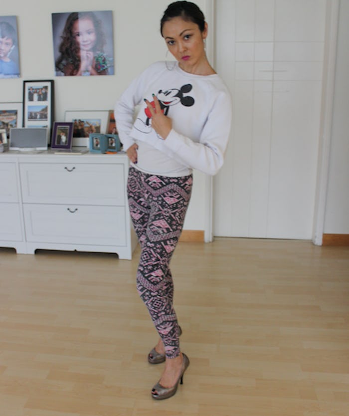 A woman dressed by her 3-year-old in a white Mickey Mouse tee and multicolored pants