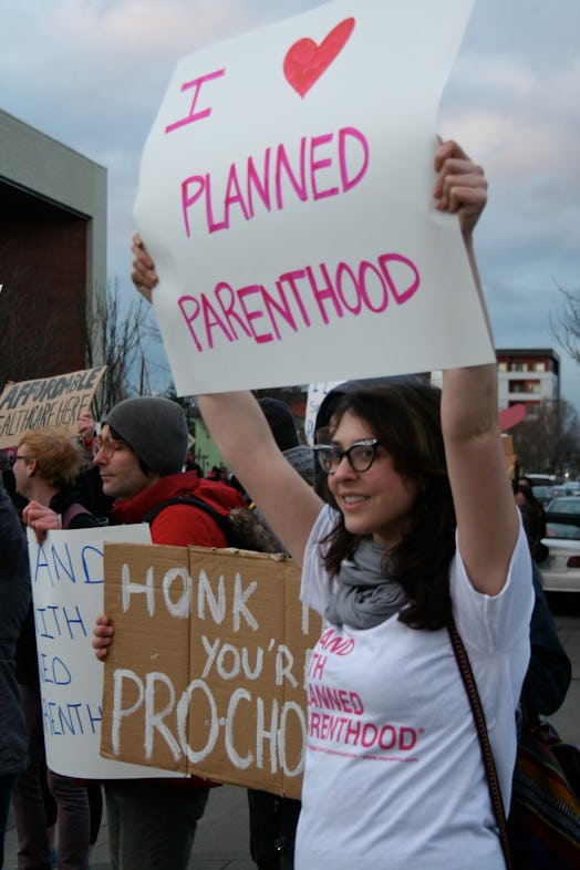 A woman holding a sign reading 'Planned parenthood.'