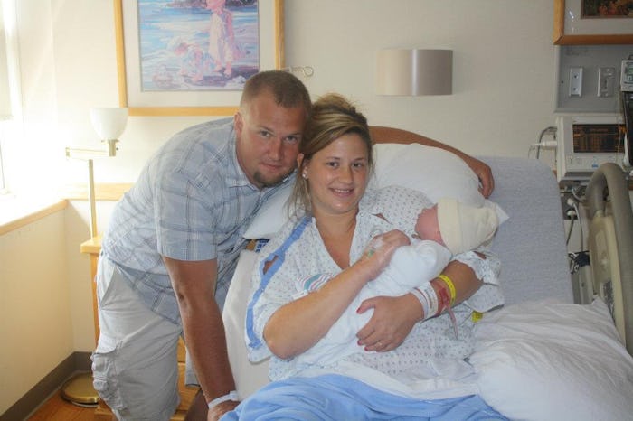 Chaunie Brusie holding her baby she got by having an Epidural in a hospital bed next to her partner
