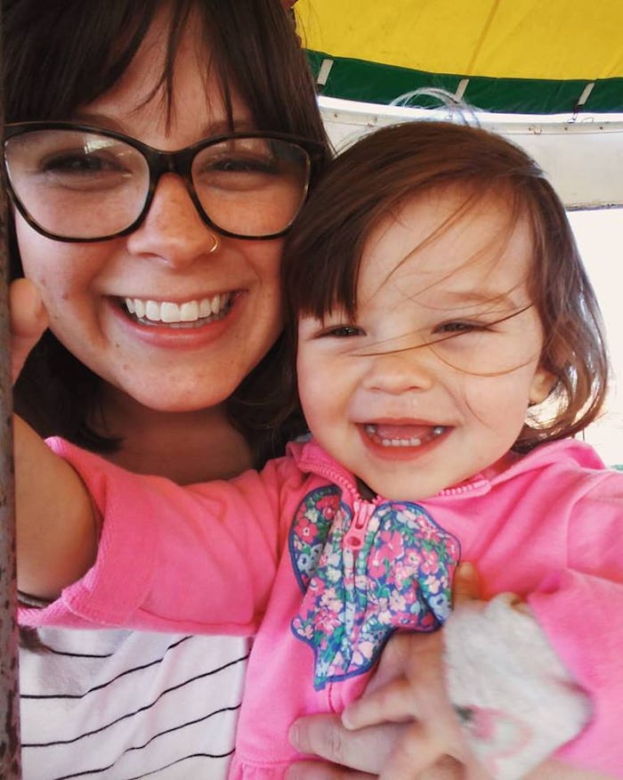Mary Sauer holding her daughter as they take a selfie together and smile at the camera