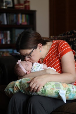 Samantha Taylor kissing her sleeping newborn baby