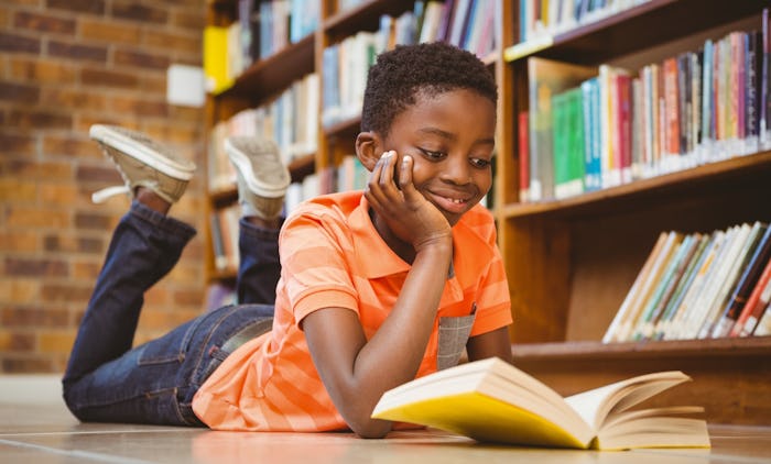 A boy reading a children’s book that is break boy stereotypes
