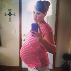 Pregnant woman taking a selfie in front of a mirror