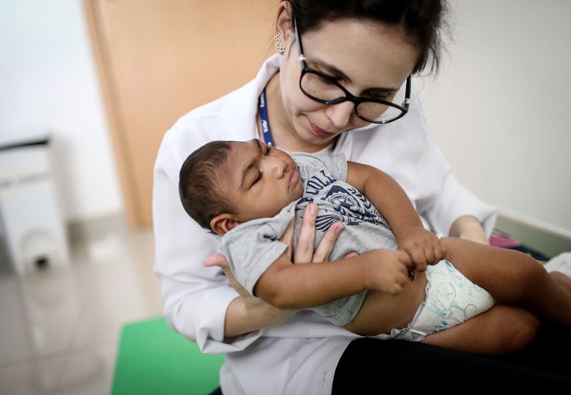 A doctor examining a baby to check for a Zika rash 