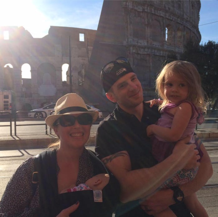 A couple of new parents holding their kid and taking a photo