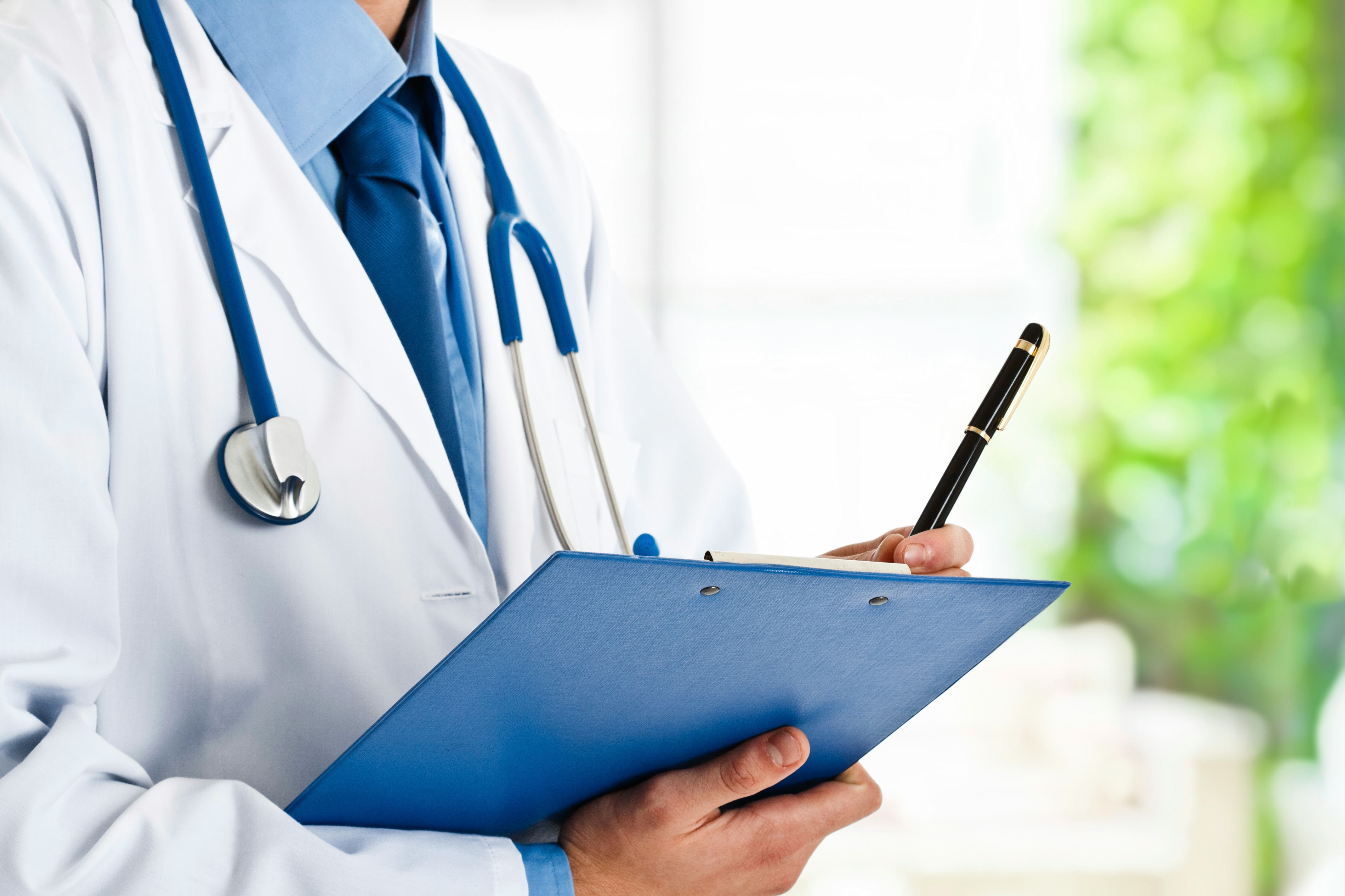 A doctor holding a clipboard looking at a patient's Zika symptoms including a fever