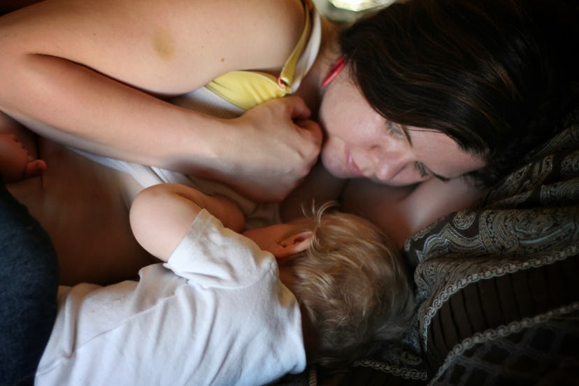 Samantha lying on the bed and breastfeeds her son