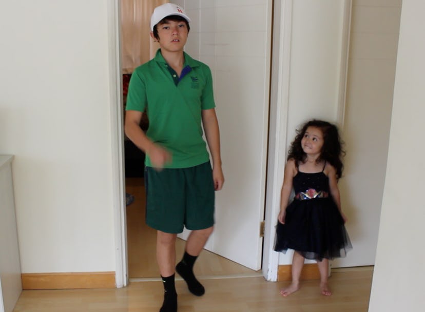 A fashion-obsessed 3-year-old standing next to her brother 