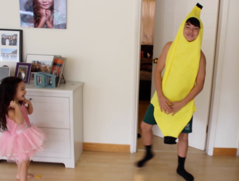 A fashion-obsessed 3-year-old standing next to her older brother wearing a banana costume
