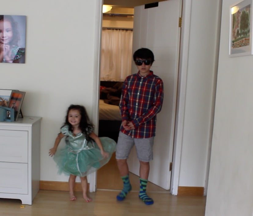 A fashion-obsessed 3-year-old standing to her brother wearing a look she picked for him