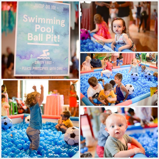 A sign for a swimming ball pool pit and lots of children playing in the pit