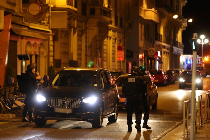 A street in France with a lot of police officers during the night