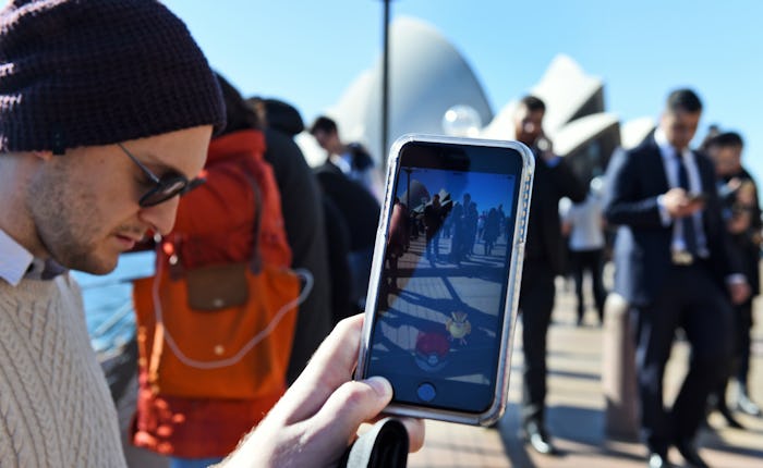 A person playing Pokemon Go in a crowded street