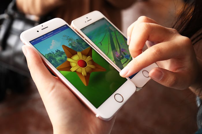 A person with two phones both of them running pokemon go